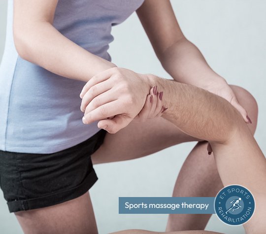 Man laying on massage table receiving arm therapy from a sports rehabilatator to improve flexibility