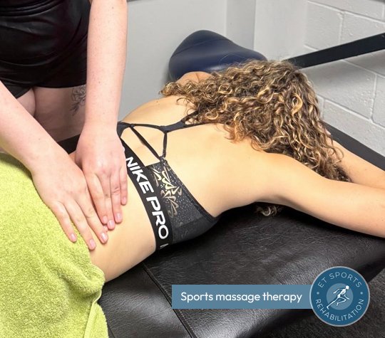 woman laying on a massage table receiving a sports massage by sports rehabilitator