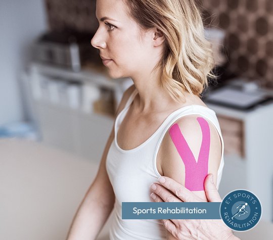 Photo of a woman sitting on a chair receiving sports taping as a sports rehabilitation treatment