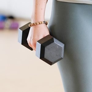 Woman training to improve muscle strength holding weights
